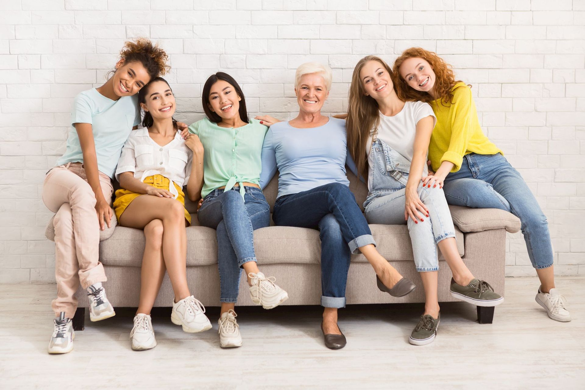 a group of women are sitting on a couch together