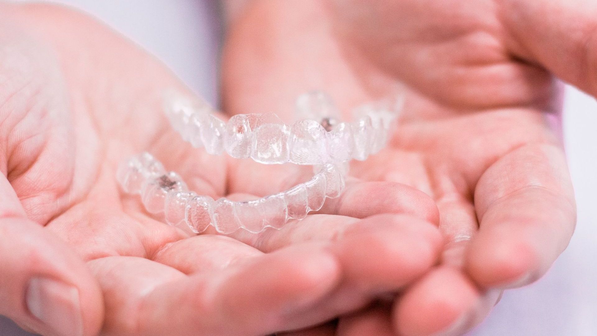 a person is holding a clear mouth guard in their hands