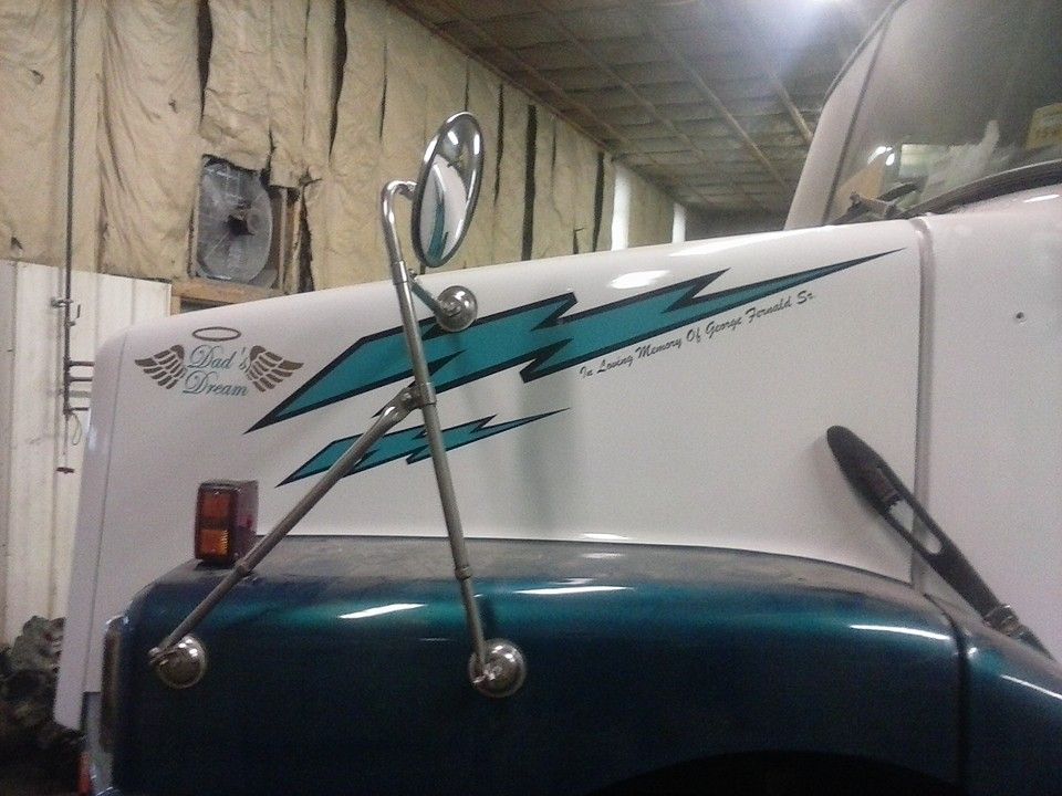 Truck's hood with blue and white paint, side mirror, a logo of wings and a lightning bolt.