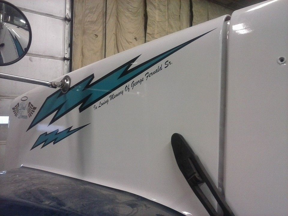 White truck cab with teal lightning bolt design, text 