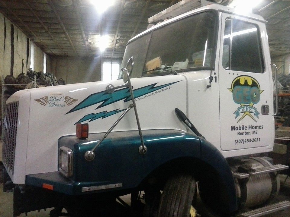 White semi-truck with teal accents, logo for 
