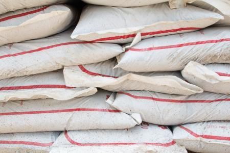 Stacked white sacks with red stripes piled in a warehouse or storage area