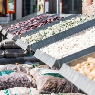 Market stall displaying assorted fresh fish on slanted trays with ice