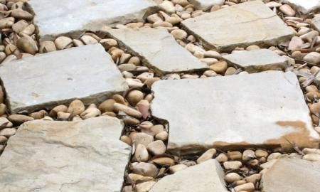 Flat stone pavers set in pebbles, forming a rustic garden path surface