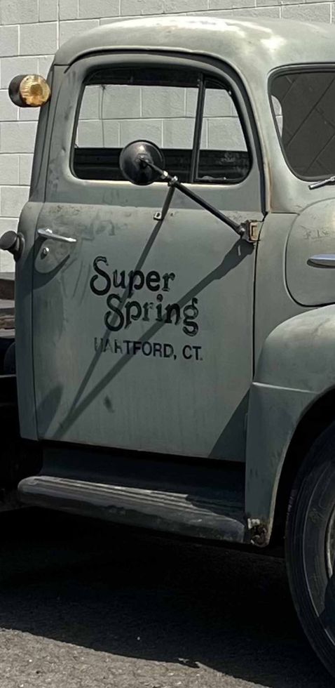 A Gray Truck Is Parked In Front Of A Brick Wall — Hartford, CT — Super Spring & Brake Co., Inc.