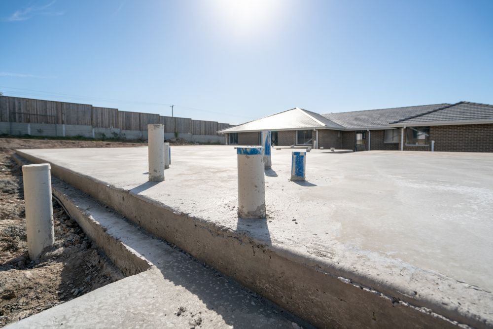 Concrete Foundation With Pipes Emerging, a Partially Built House — Rowal Constructions in Wallsend, NSW