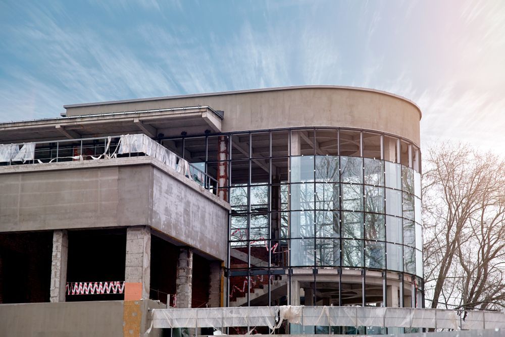 Building Under Construction With Curved Glass Windows and Concrete Facade — Rowal Constructions in Mayfield, NSW