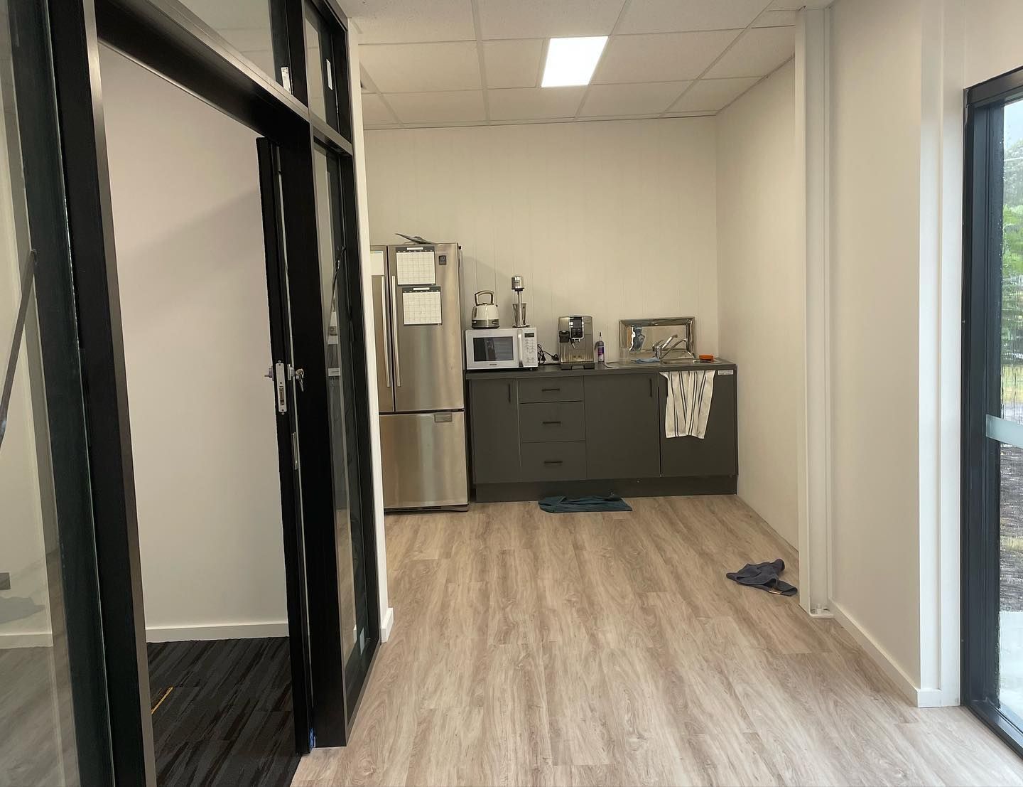 Interior Kitchen With Fridge, Microwave, Cabinetry, and Flooring — Rowal Constructions in Kotara, NSW