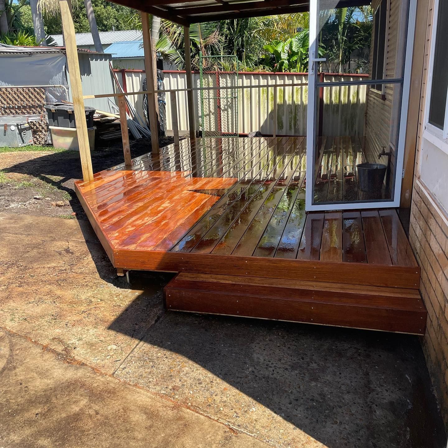 Wooden Deck With a Step, Next to a House With a Screen Door and Metal Fence — Rowal Constructions in Merewether, NSW