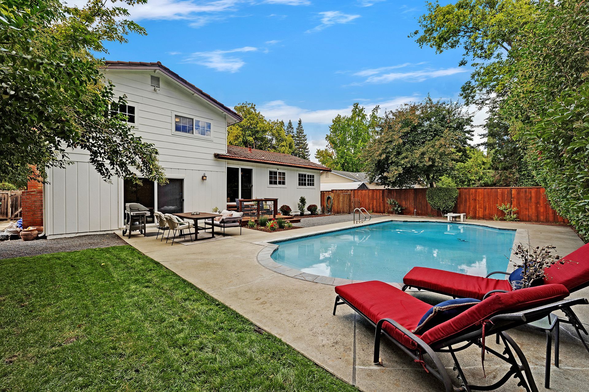 A living room with a couch , chairs , ottoman and a mirror