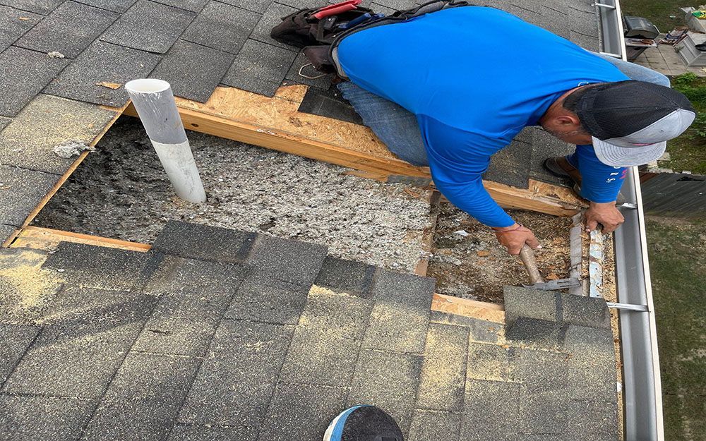 A man from Texas Pro Roofing is working on a roof with a hammer in San Antonio.