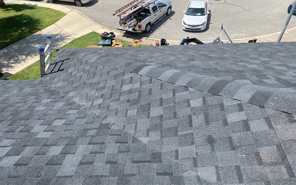 A roof with a lot of shingles is being installed on a house in San Antonio.