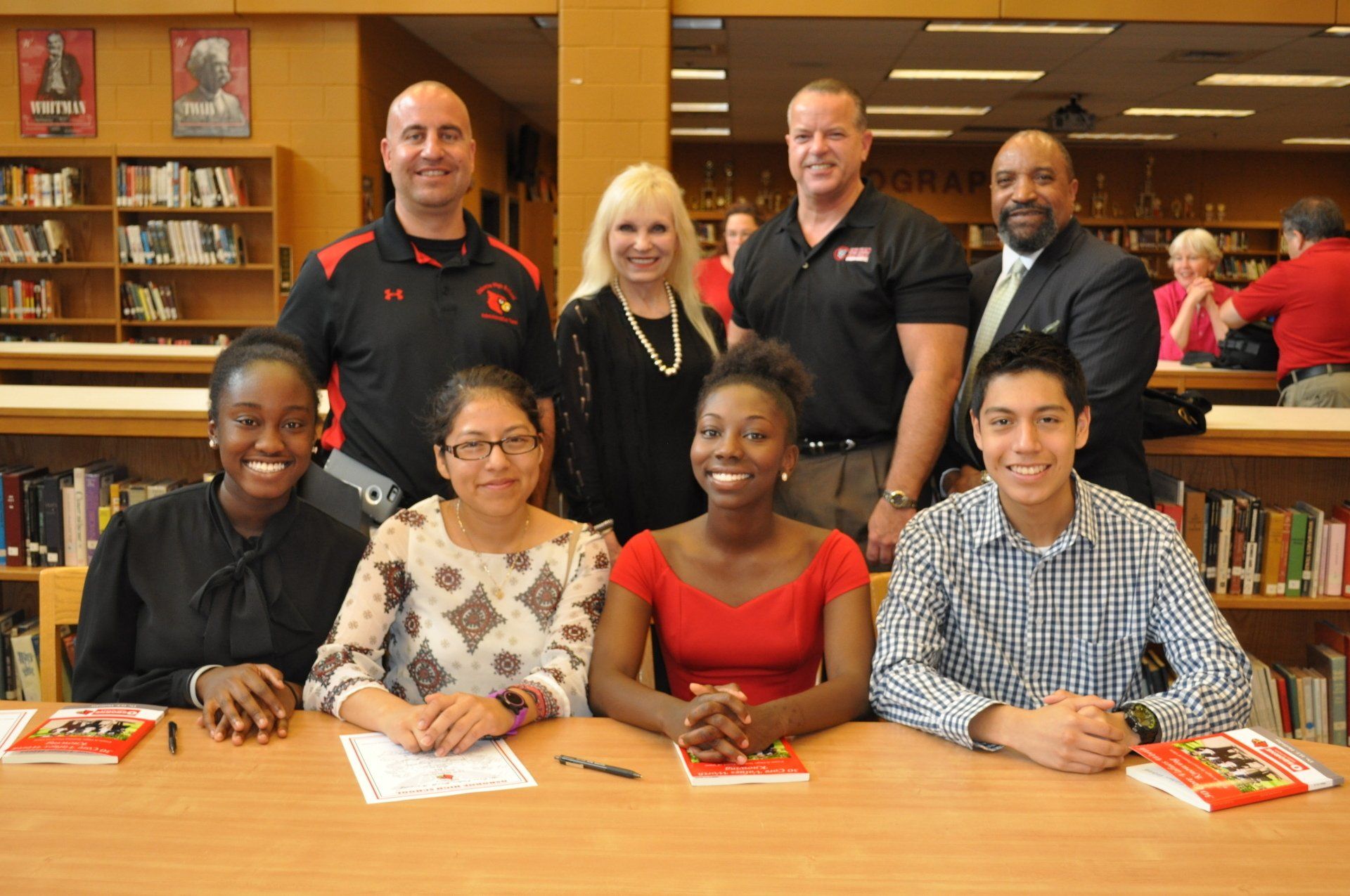 A group of people are posing for a picture in a library.