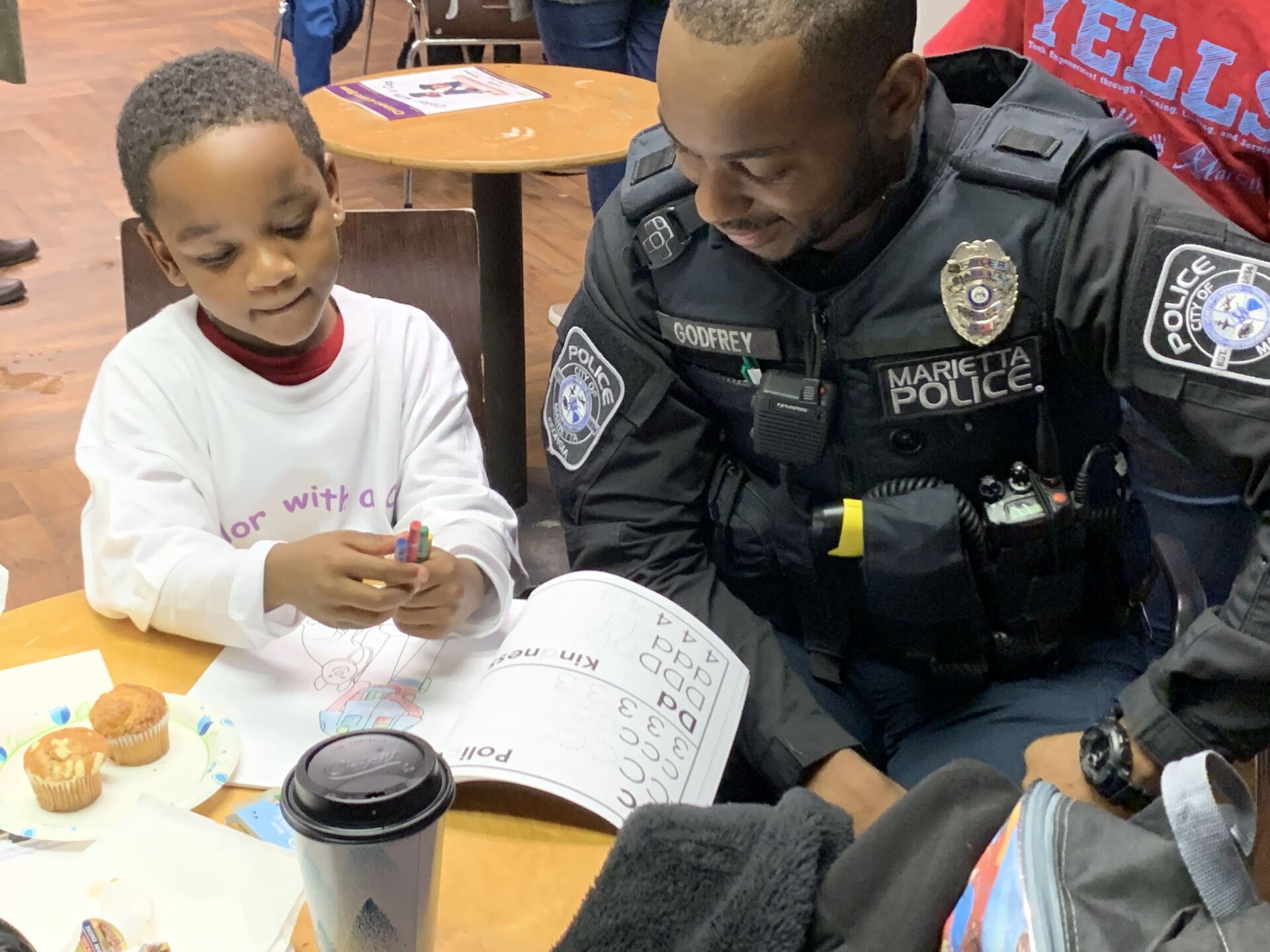 A police officer is helping a young boy with his homework.