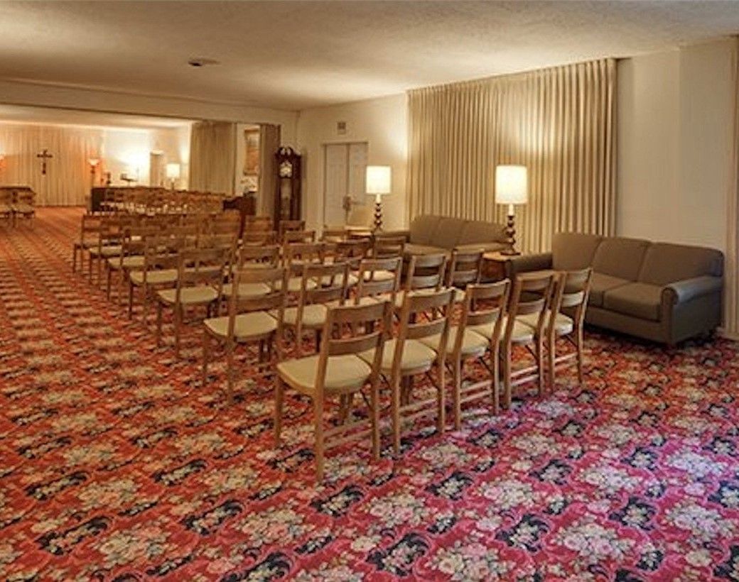 A large room with rows of chairs and a couch.