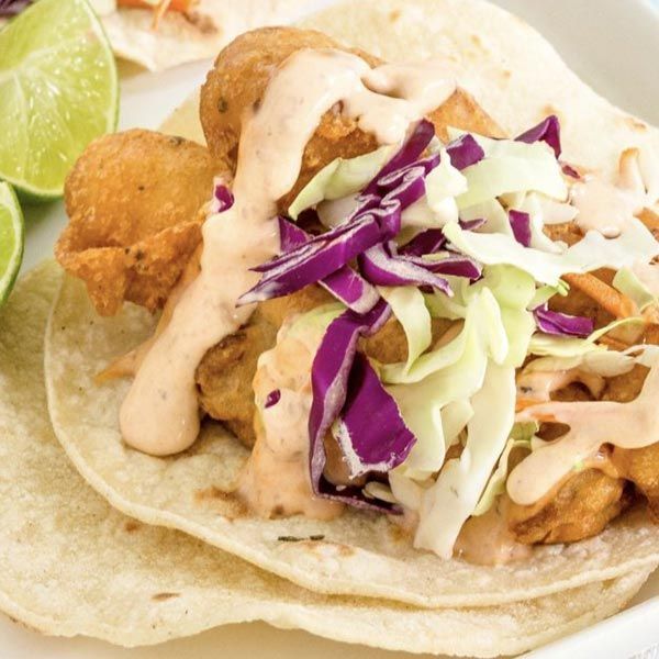 A close up of a taco with cabbage and sauce