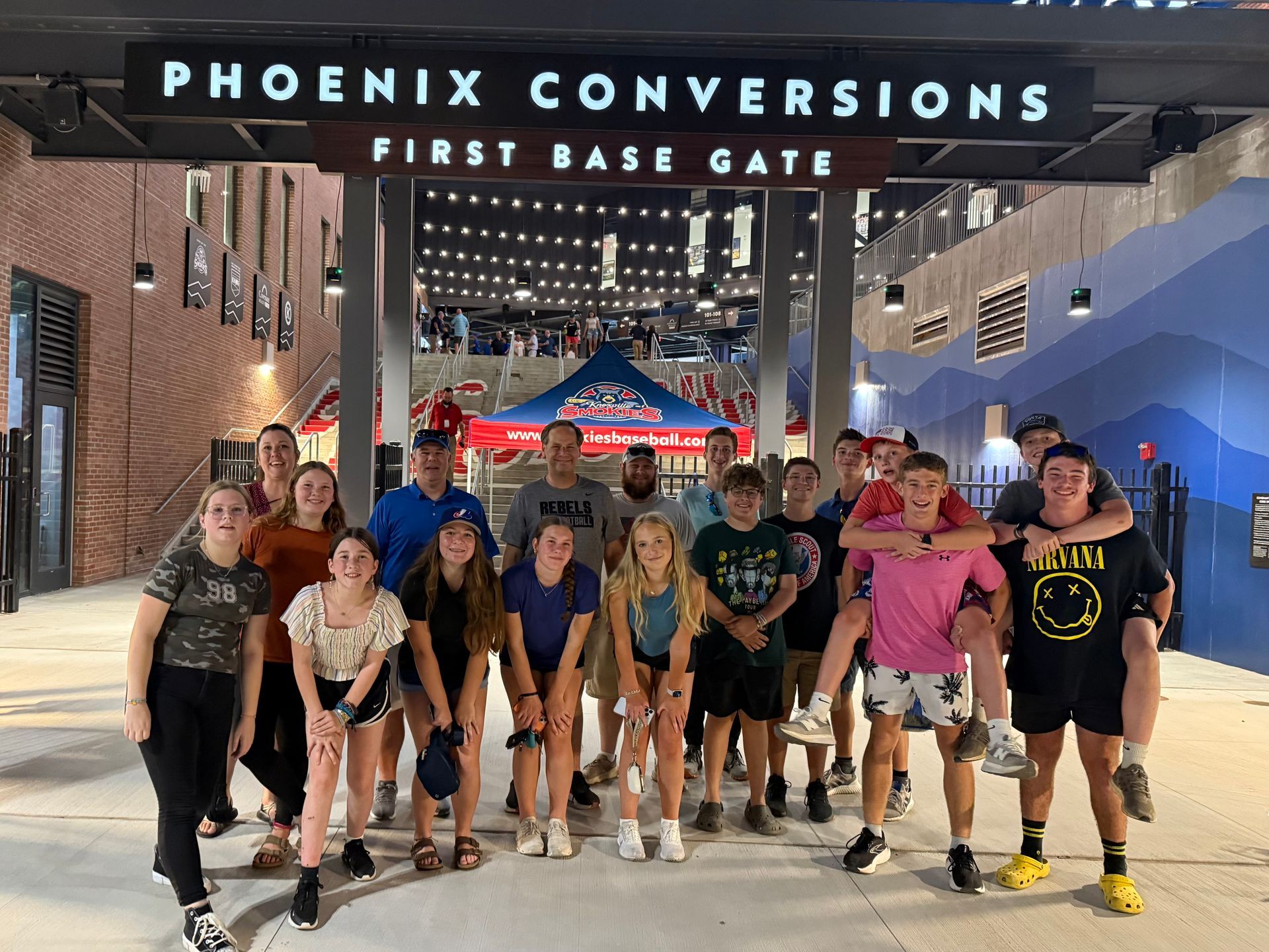 Group of youth posing in front of the Phoenix Conversions First Base Gate at the Knoxville Smokies Stadium 