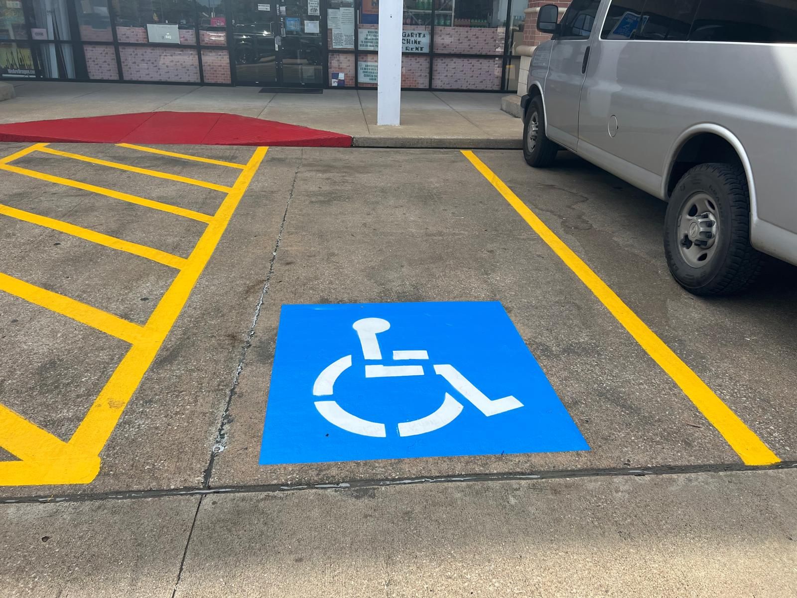 Person pressure washing the sidewalk in front of a brick building at night.