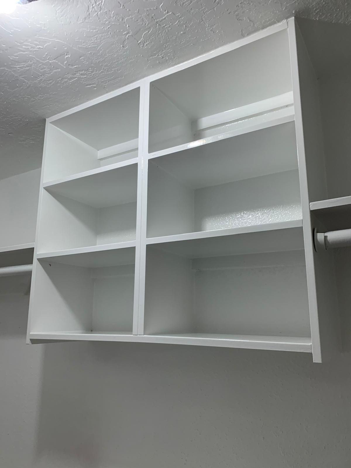 White closet shelves mounted on a wall, ready for storage.