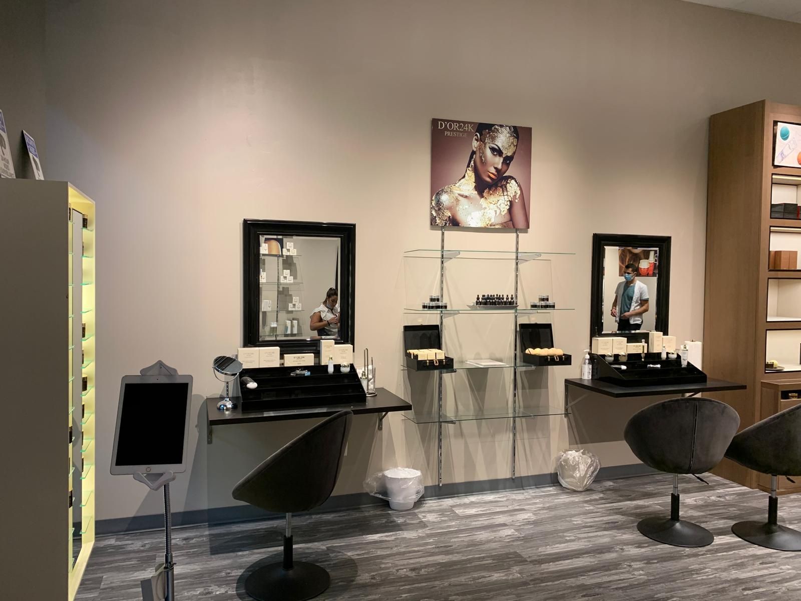 Jewelry store interior with display cases, mirrors, seating, and a portrait of a woman.