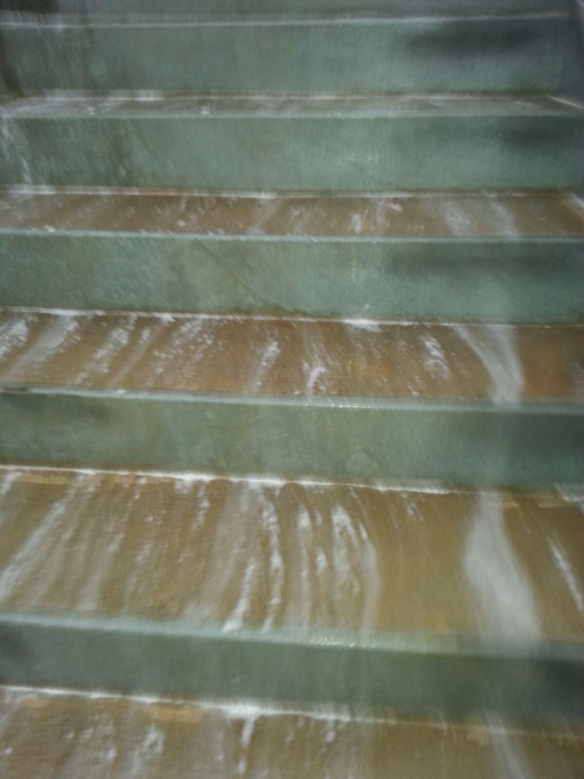 Green and brown marble stairs with a water-like or chalky substance on each step.
