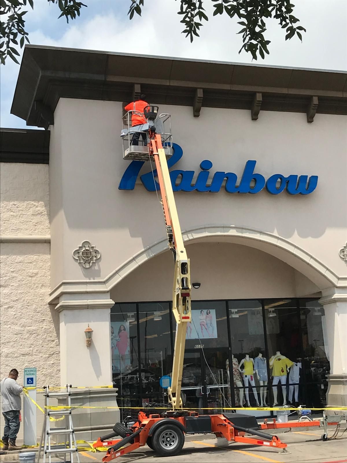 A person in an orange shirt on a lift repairing the 