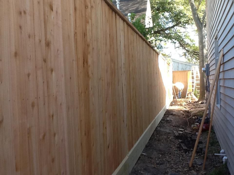 Wooden fence alongside a house, in an outdoor setting.