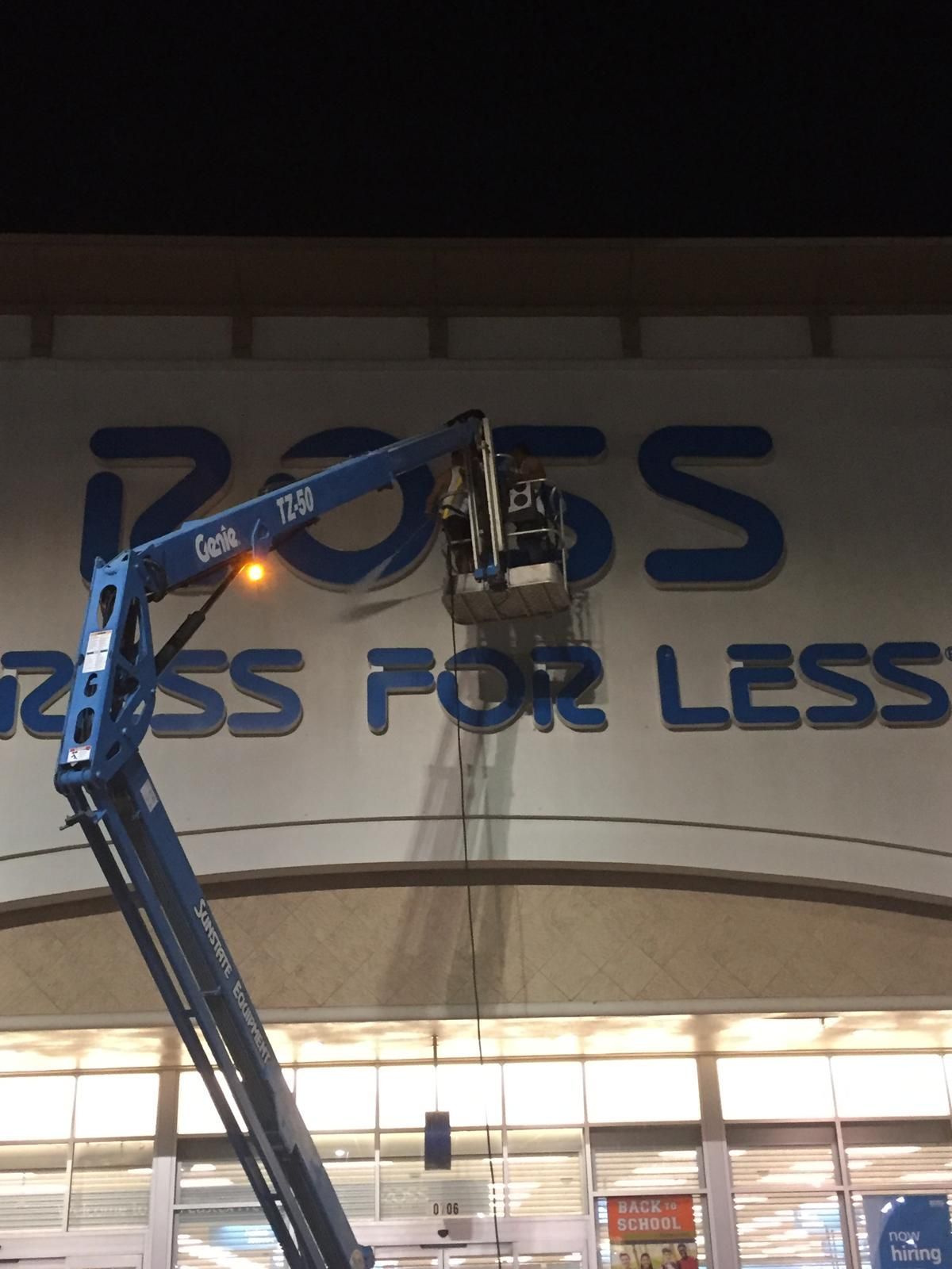 Workers in a blue lift installing a blue 