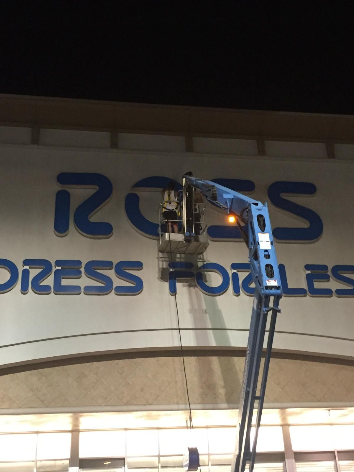 A worker in a lift repairing the blue 