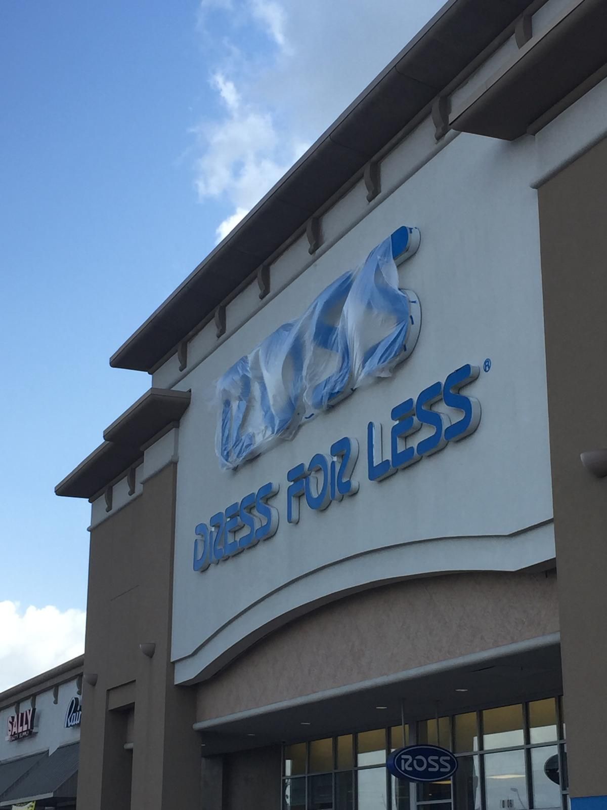 Ross Dress for Less store exterior with blue lettering against a cream-colored building and a bright blue sky.