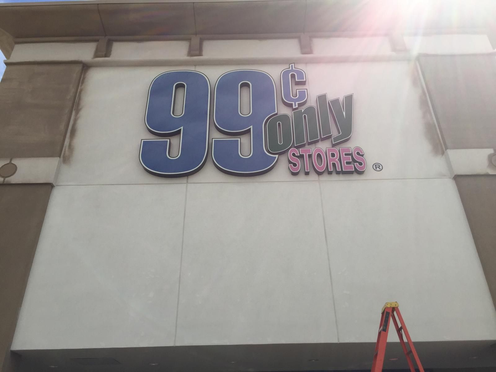 99¢ Only Stores sign on a beige building with blue and black text. Orange ladder at the bottom.