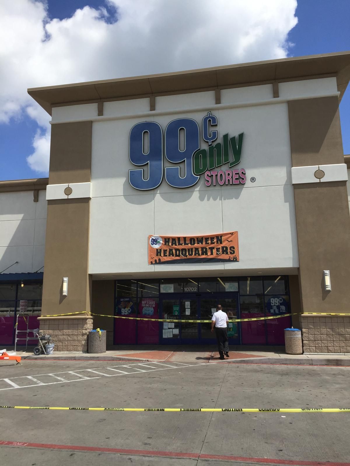 A 99 Cents Only store entrance, taped off with yellow caution tape; a person stands nearby.