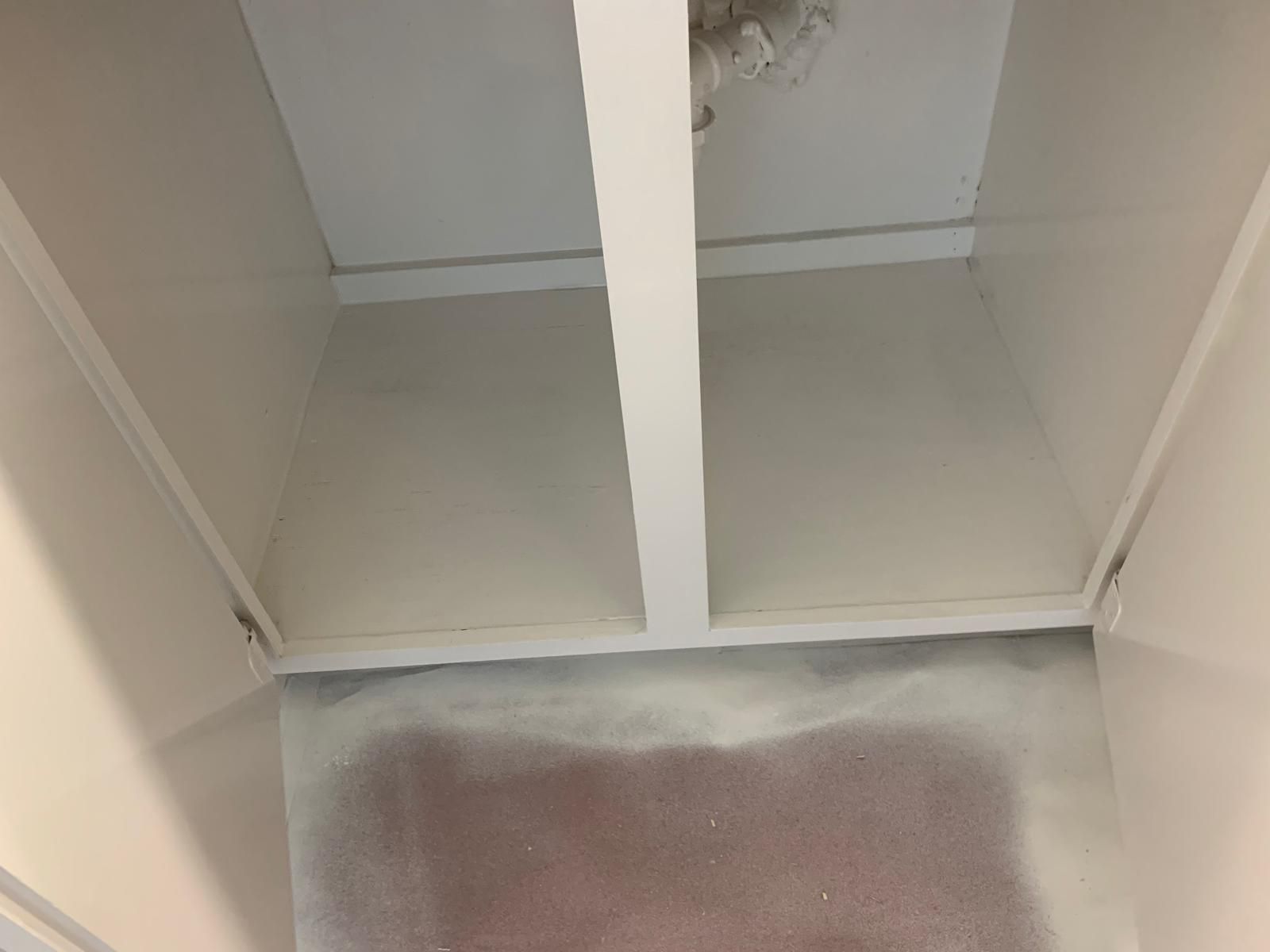 Interior of a white-painted, rectangular space, possibly a closet or cabinet. White beams across the ceiling.