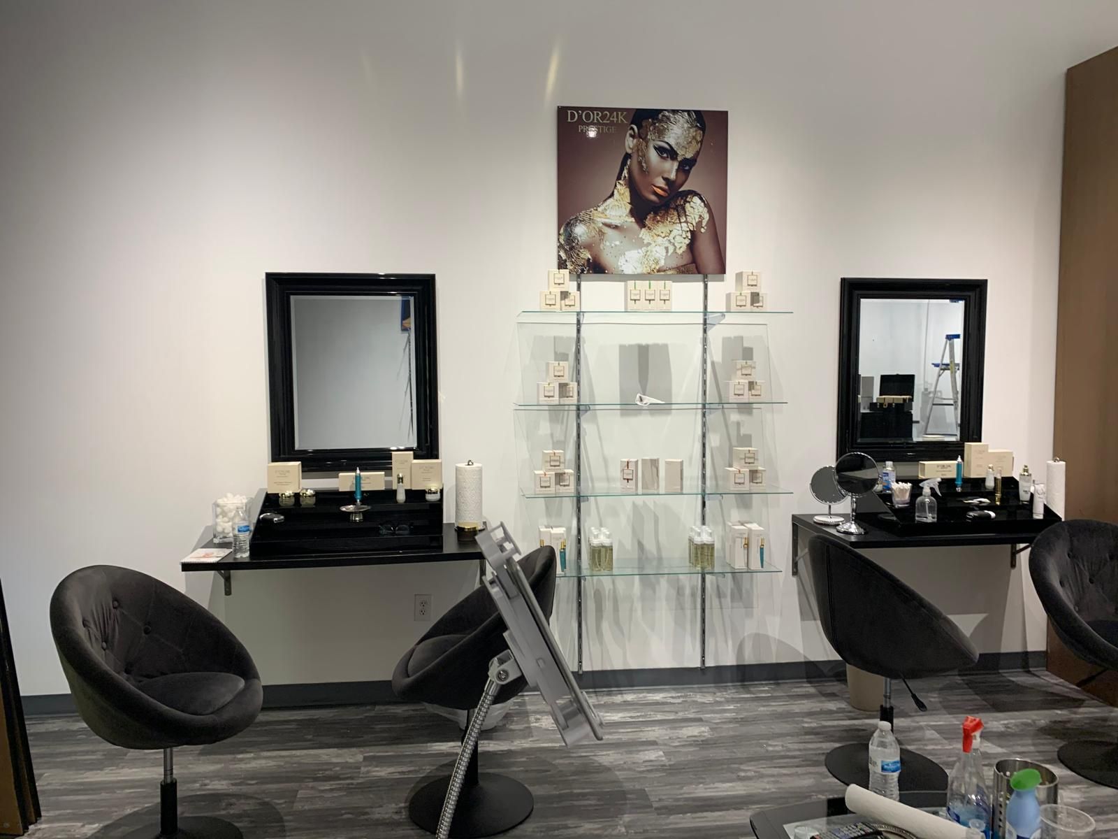 Hair salon interior with mirrors, chairs, and product displays. Beige, black, and gray color scheme.
