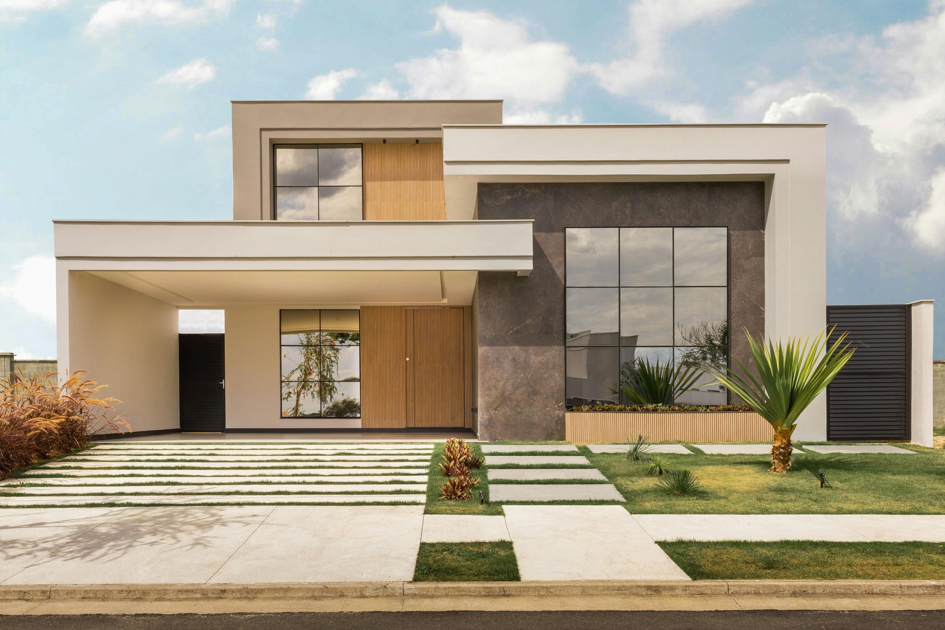 Modern two-story house with light and dark gray accents, wood paneling, and a carport.
