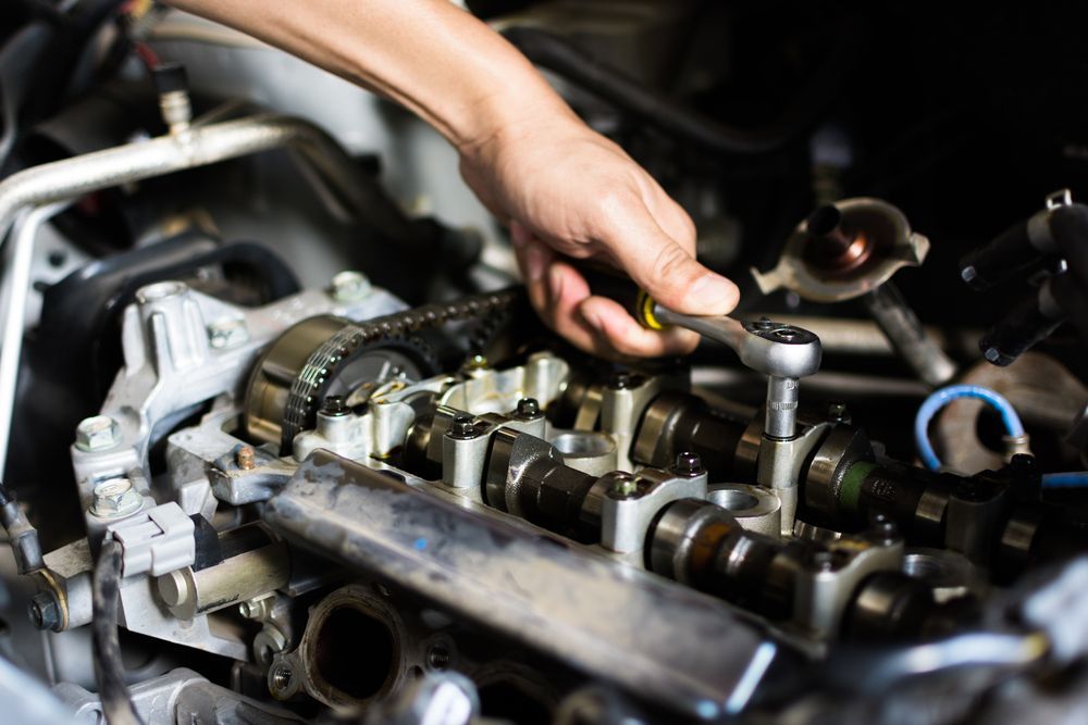A Person Is Working On A Car Engine With A Wrench — Absolute Transmissions NQ In Hyde Park, QLD