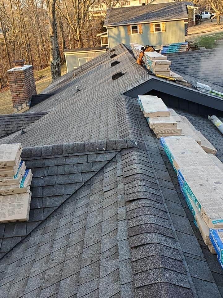 A roof with a lot of shingles on it is being built on a house.