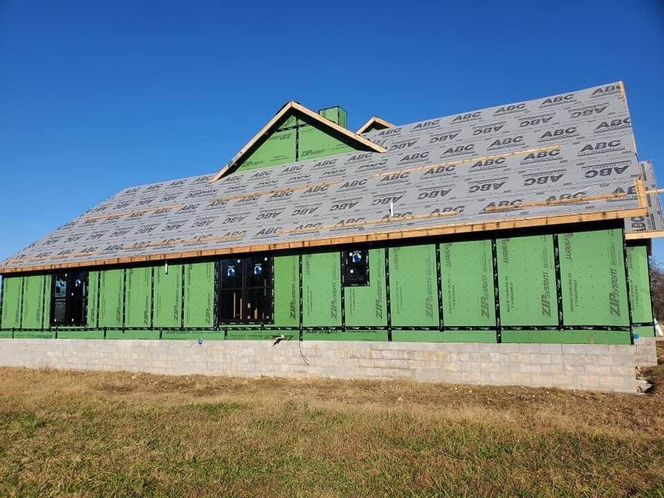 a house that is being built with green siding