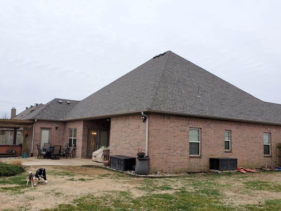 A brick house with a dog standing in front of it