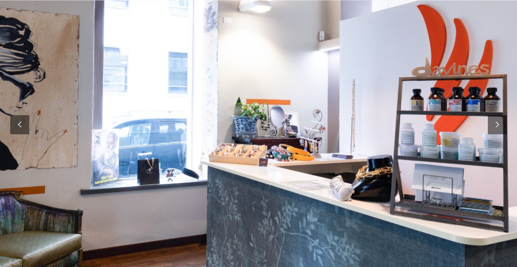 Banco della reception in un salone con esposizione di prodotti al dettaglio, accanto a una finestra con vista sulla strada.