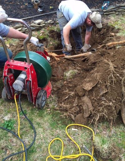 A man is using a machine to dig a hole in the ground.
