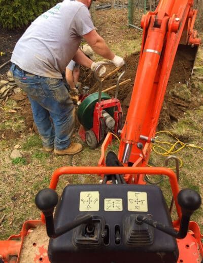 A man is using an excavator to dig a hole in the ground.