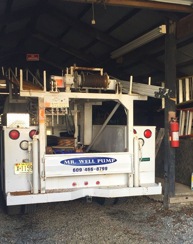 A mr. well pump truck is parked in a garage