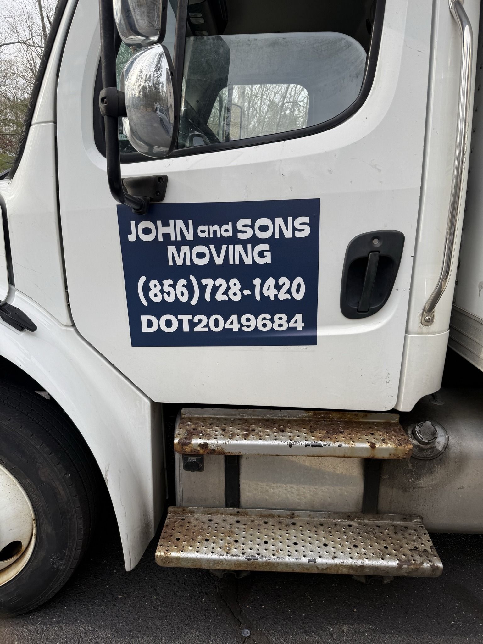 White moving truck with blue sign: