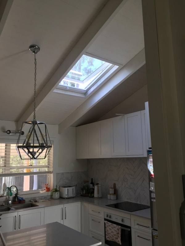 Kitchen with white cabinets and a skylight — Lilydale, QLD — SunCity Skylights
