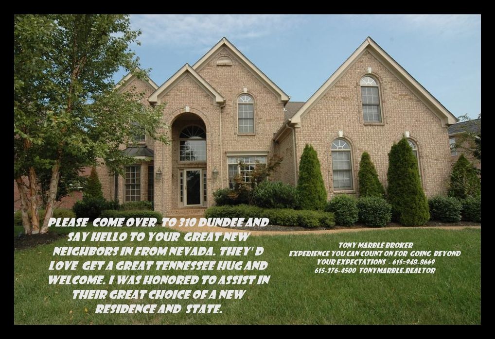 A dining room with a table and chairs and a wooden staircase.