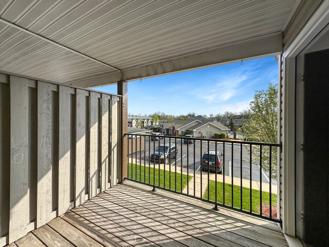 A balcony with a railing and a view of a parking lot.