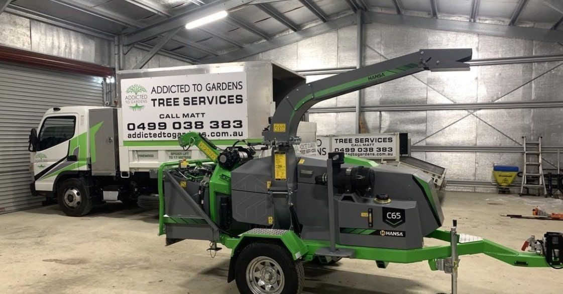 Truck and wood chipper inside a garage. The truck has 