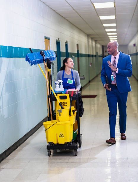 Janitor talking with manager in hallway while providing commercial cleaning services.