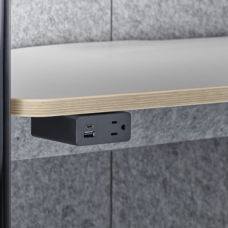 Desk edge power strip with USB and outlet ports mounted beneath a tabletop